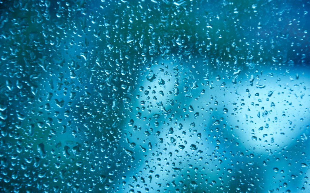 Dancing Dew: Mesmerizing Water Drops on a Glass Pane, with Stunning Bokeh Effects against Blue Water Background - A Captivating 4K Wallpaper Background Photograph