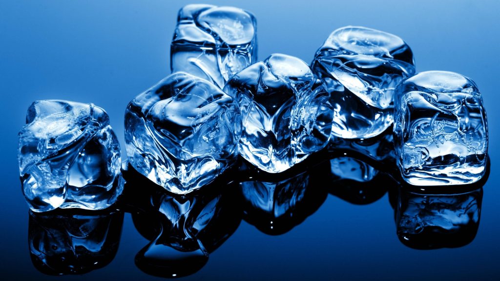 Macro photo of clear ice cubes melting on glossy dark surface with cool blue light wallpaper