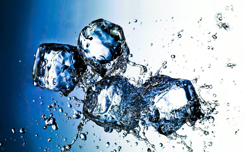Crystal clear ice cubes splash midair with sparkling water droplets on blue white gradient background Wallpaper