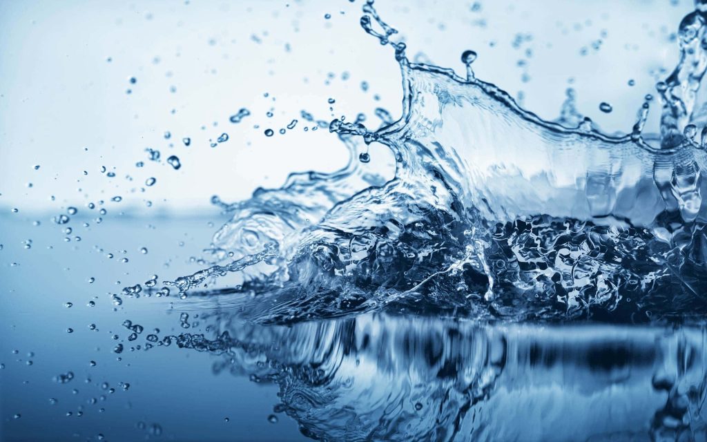 High-speed macro photo of crystal-clear water splash crown with blue droplets dynamic motion Wallpaper