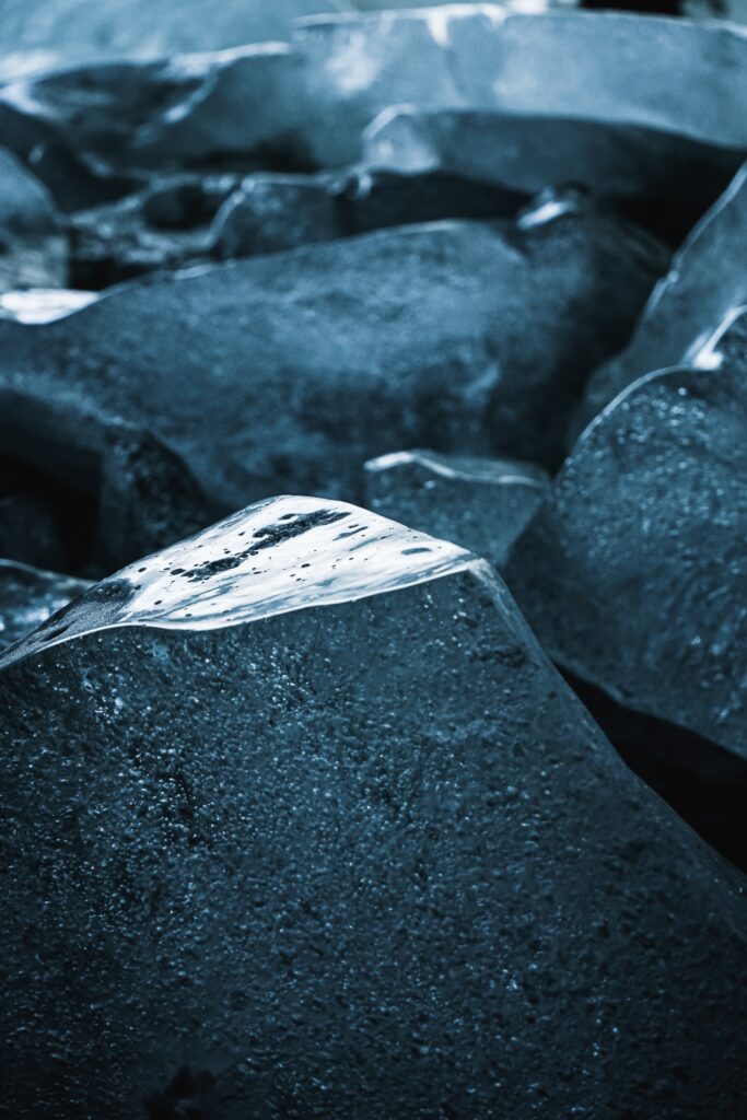 Close-up of translucent ice lumps and jagged shards with cool blue tones and glossy textures Wallpaper