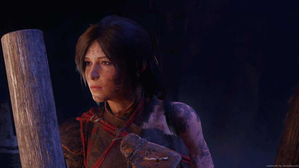Curiosity Awakens: Lara Croft's Enigmatic Gaze Amidst the Shadows of Tomb Raider Wallpaper