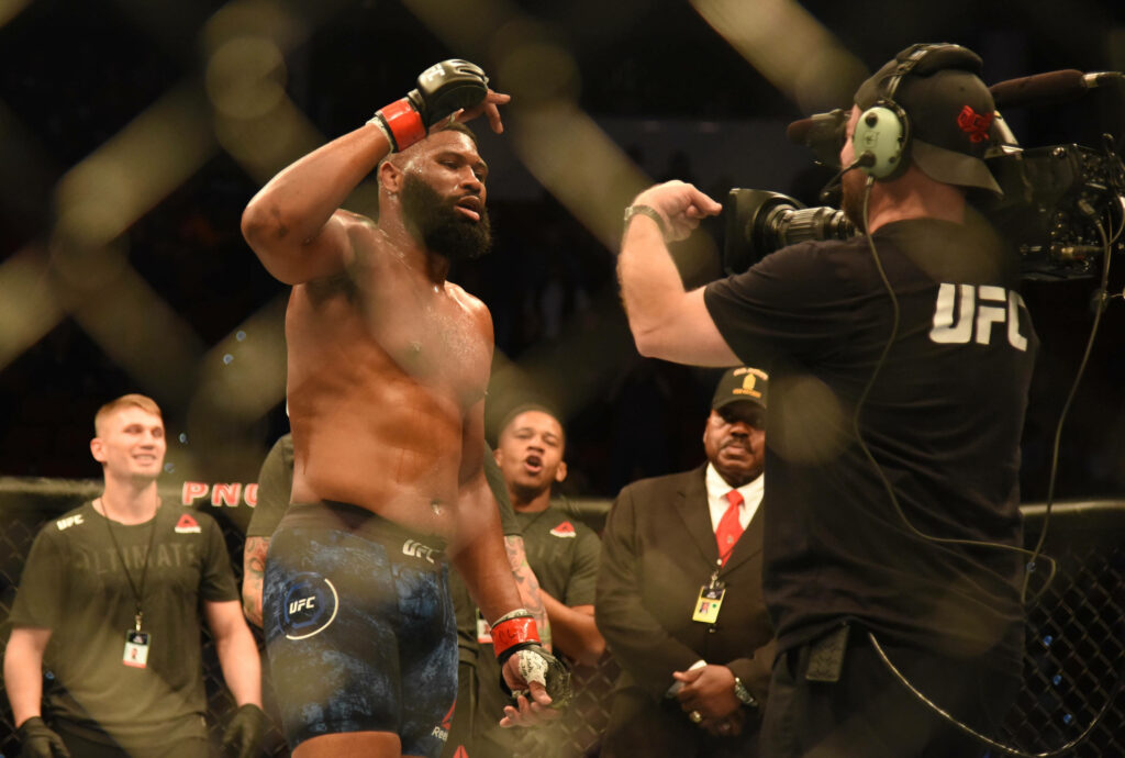 Curtis Blaydes shirtless in UFC octagon posing confidently after fight with team and officials Wallpaper
