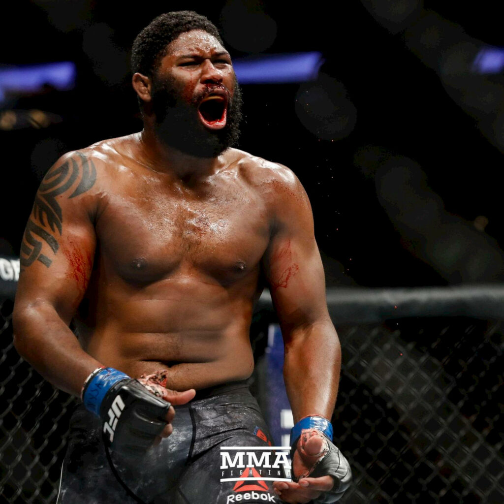 Curtis Blaydes in octagon intense MMA fighter powerful physique battle marks arena lighting Wallpaper