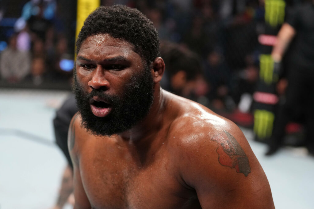 Curtis Blaydes panting inside UFC octagon showing muscular physique and focused MMA determination Wallpaper