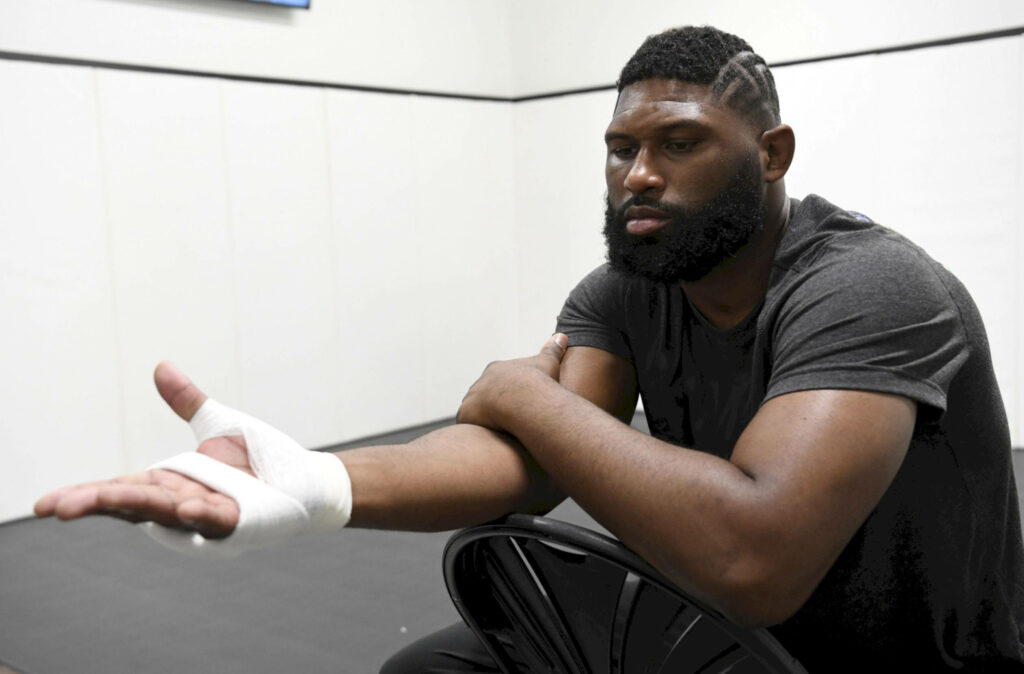Curtis Blaydes in training room with bandaged hand showcasing post fight resilience and focus Wallpaper