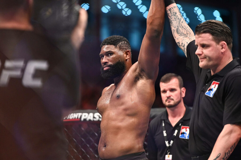 Curtis Blaydes celebrates UFC victory in octagon spotlight with officials and vibrant arena crowd Wallpaper