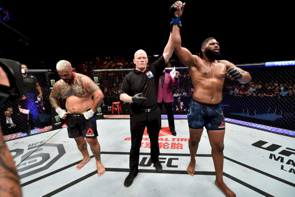 Curtis Blaydes wins MMA fight with arm raised by referee against Mark Hunt intense match background Wallpaper