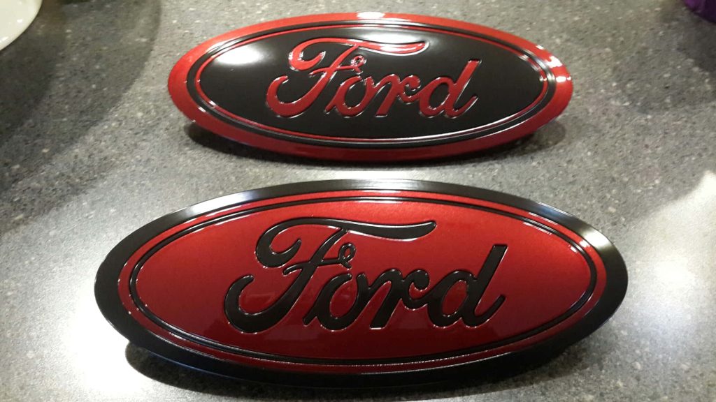 Custom Ford emblems black and metallic red on speckled grey countertop automotive wallpaper background