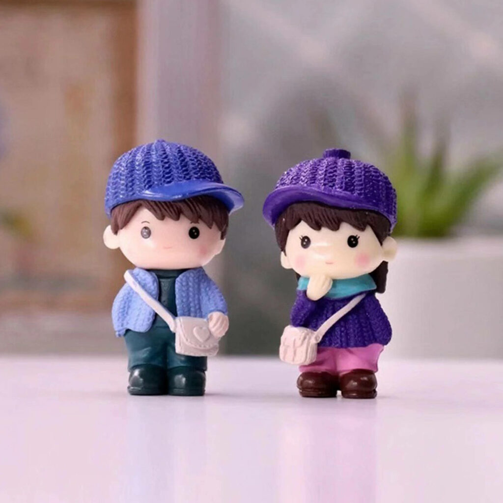 A Delightful Mini-doll Duo Posing Adorably in Matching Couple Attire, Complete with Majestic Purple Hats - Lovely Doll Couple Background Snapshot Wallpaper