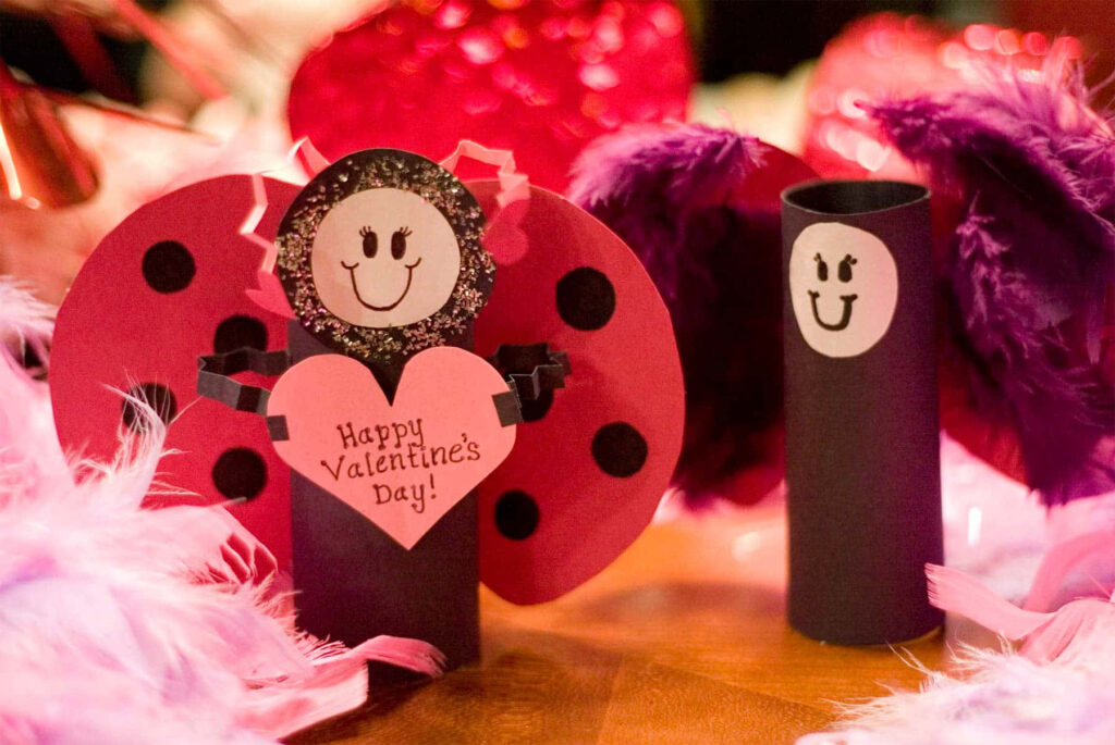 Handmade paper ladybug cutouts with hearts smiling Valentines Day wallpaper background