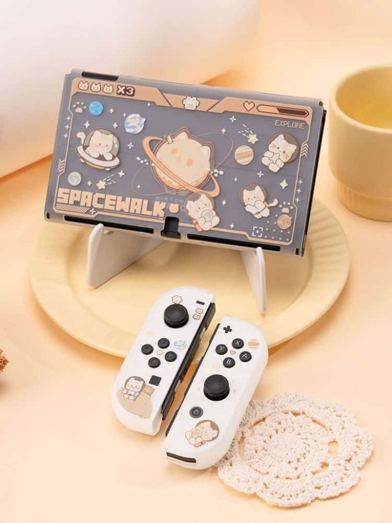 Nintendo Switch with white Joy-Cons featuring cute space cat planets skin on soft beige background Wallpaper