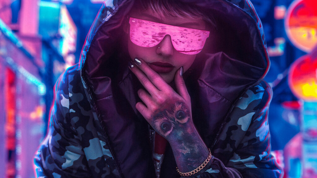 Cyberpunk Chic: A Badass Babe Flaunting Pink Shades, a Camo Jacket, and an Owl Tattoo in a Blurry Urban Setting Wallpaper