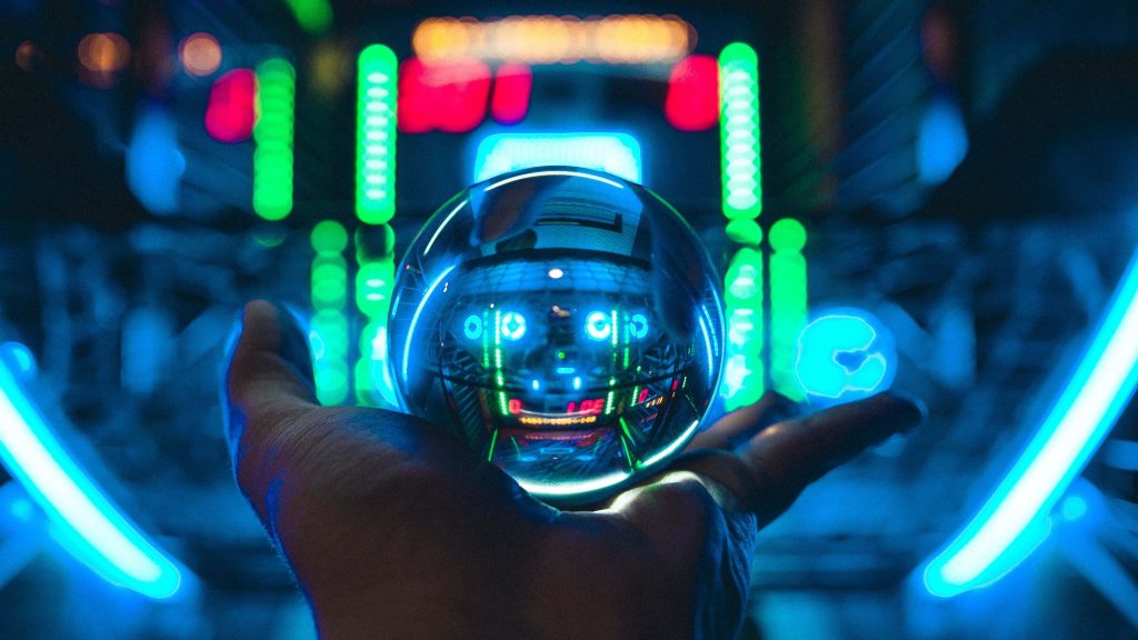 Cyberpunk wallpaper with hand holding crystal ball showing neon robot and glowing cityscape