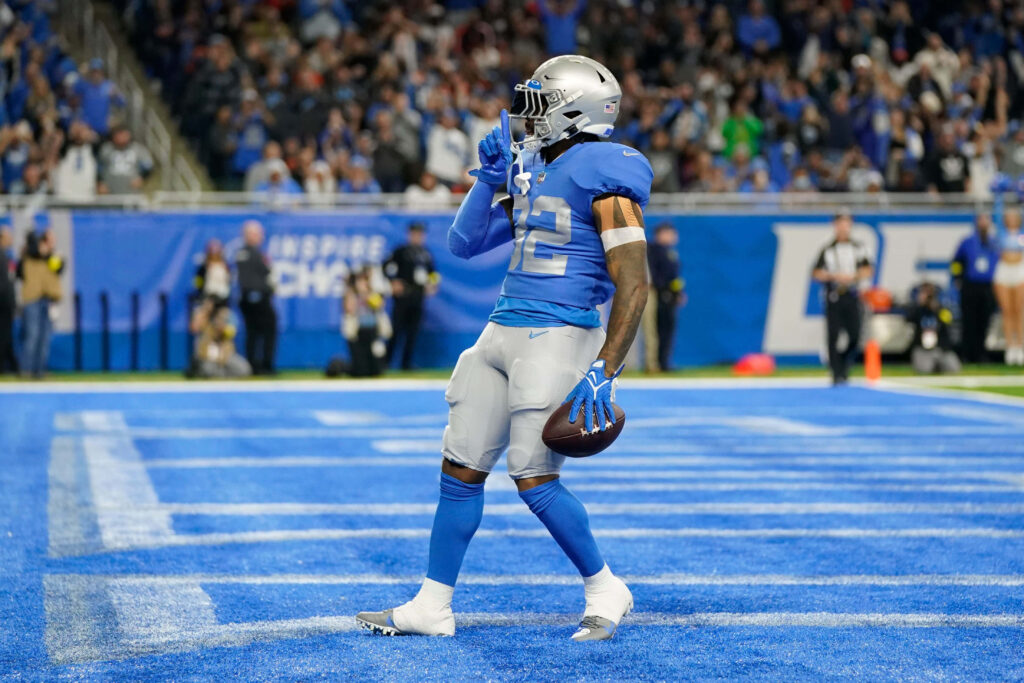 D'Andre Swift celebrates Detroit Lions touchdown in vibrant blue and silver uniform stadium wallpaper