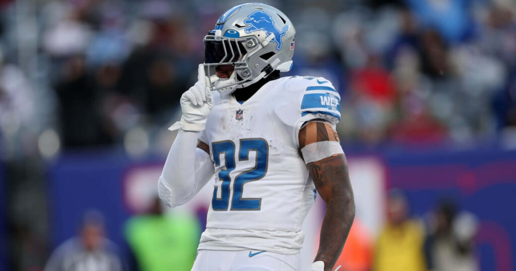 DAndre Swift of Detroit Lions number 32 in white blue uniform making gesture on field intense Wallpaper