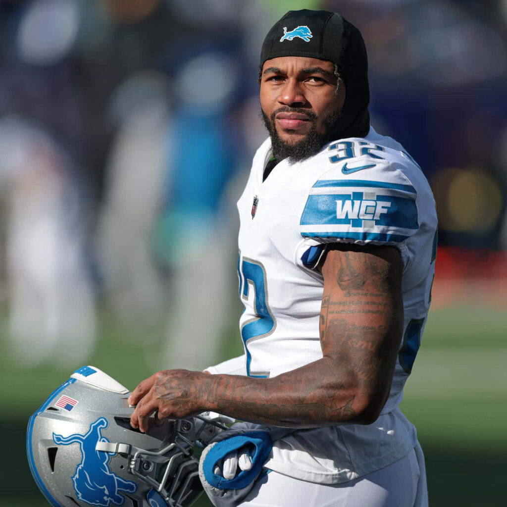 NFL running back DAndre Swift in Detroit Lions blue and white uniform on the football field Wallpaper