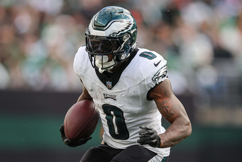 DAndre Swift running with football in Philadelphia Eagles uniform intense game day action Wallpaper