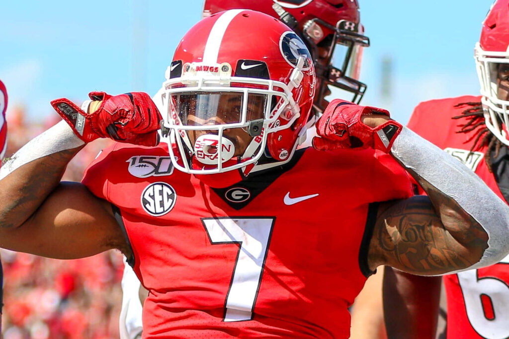 D'Andre Swift in Georgia Bulldogs uniform celebrates on football field in bright daylight Wallpaper