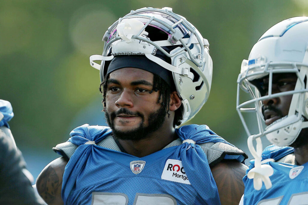 NFL player D'Andre Swift focused in blue training gear during outdoor football practice session wallpaper
