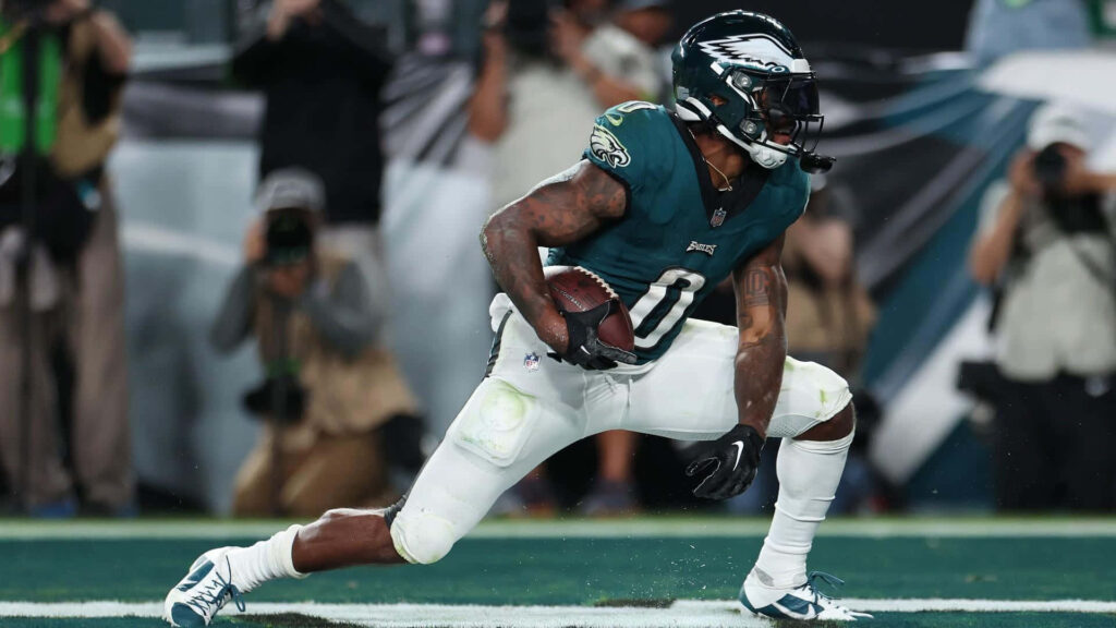 DAndre Swift in Philadelphia Eagles midnight green uniform charges forward on blurred stadium background Wallpaper