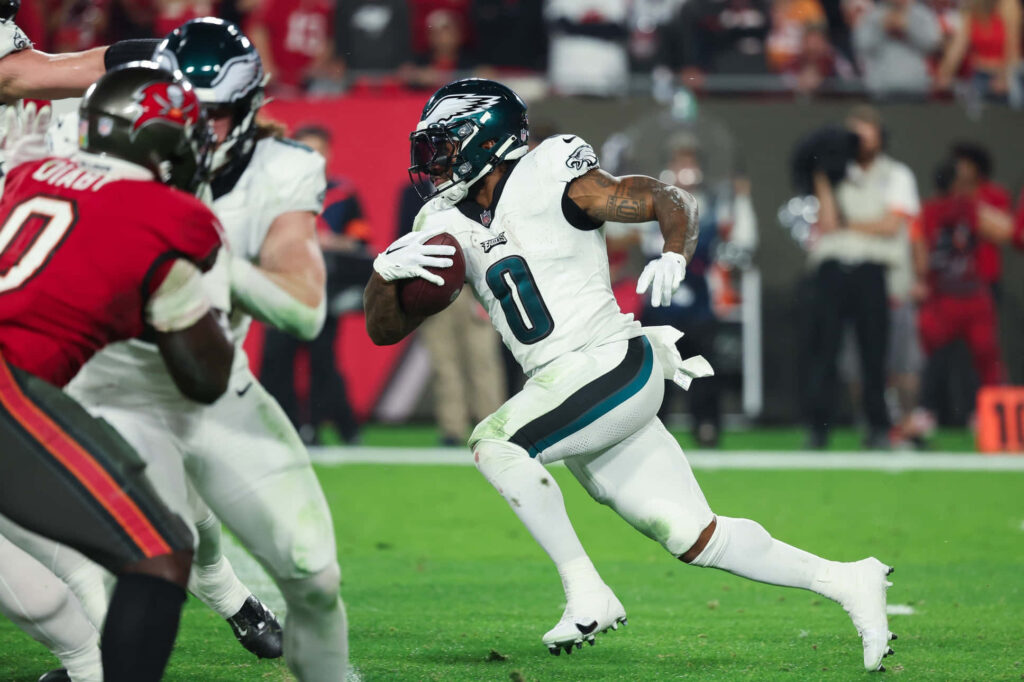 DAndre Swift in Philadelphia Eagles uniform evades defenders showcasing speed and agility on field Wallpaper