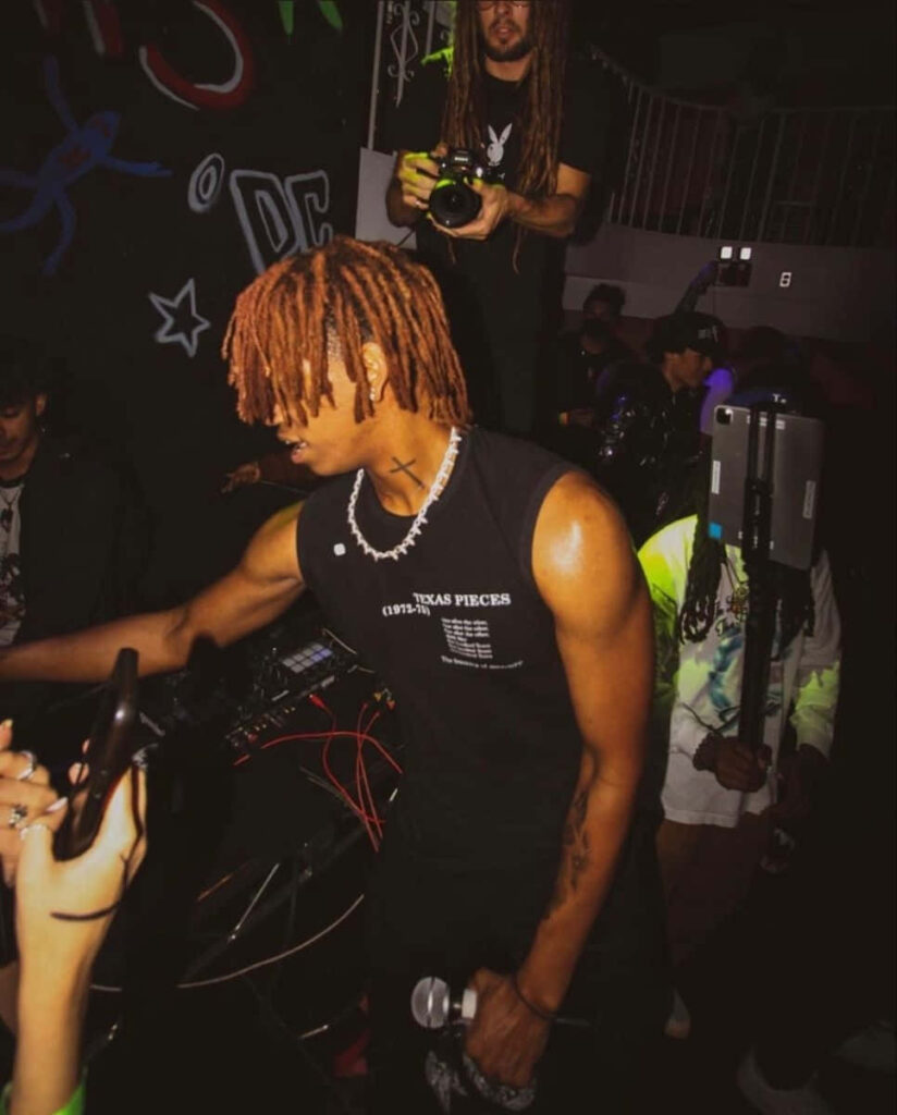 DC The Don performing live with signature dreadlocks bold fashion in vibrant concert setting Wallpaper