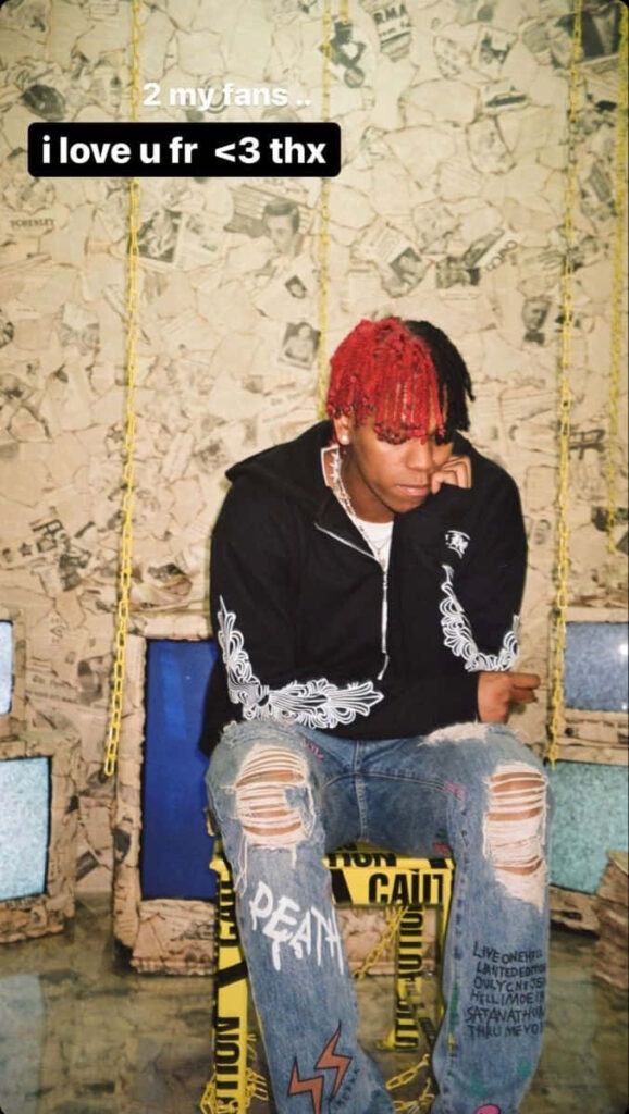DC The Don with red and black hair on caution-taped swing urban rapper style collage wall background Wallpaper