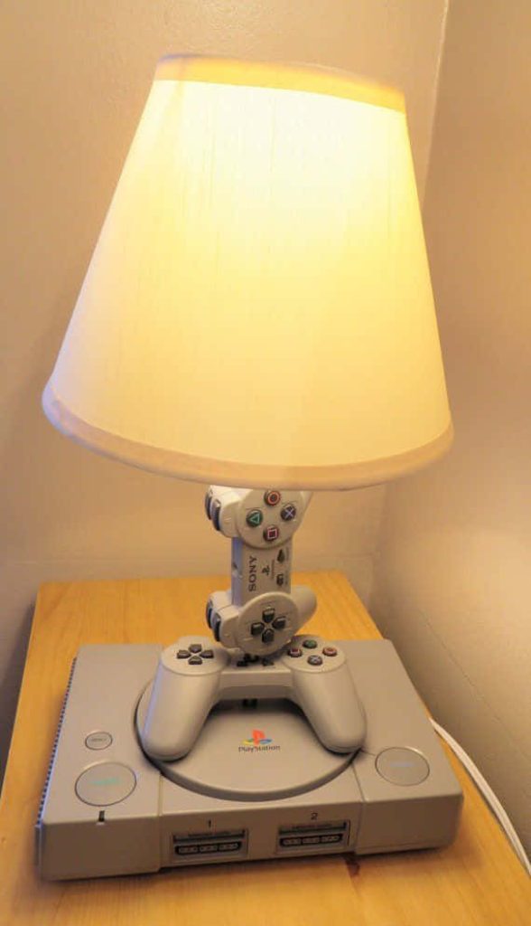 DIY lamp with Sony PlayStation 1 base and retro controller stem creating warm gaming glow Wallpaper