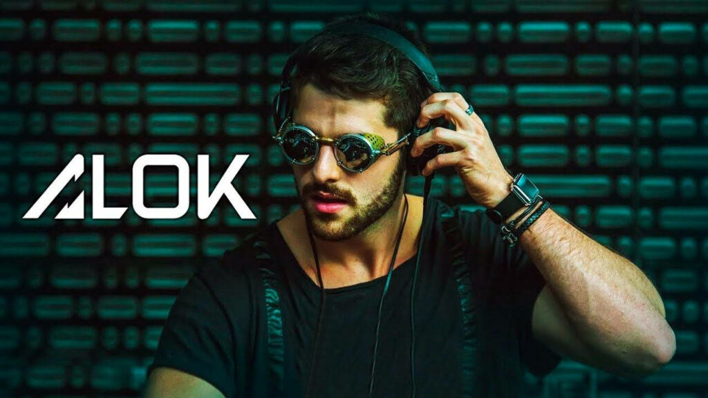 Dj Alok showcasing his style with an Apple Watch and sleek black headset in Free Fire's captivating environment Wallpaper