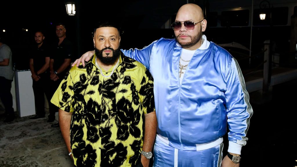 DJ Khaled and Fat Joe pose stylishly at an evening hip hop event in bold colorful outfits Wallpaper
