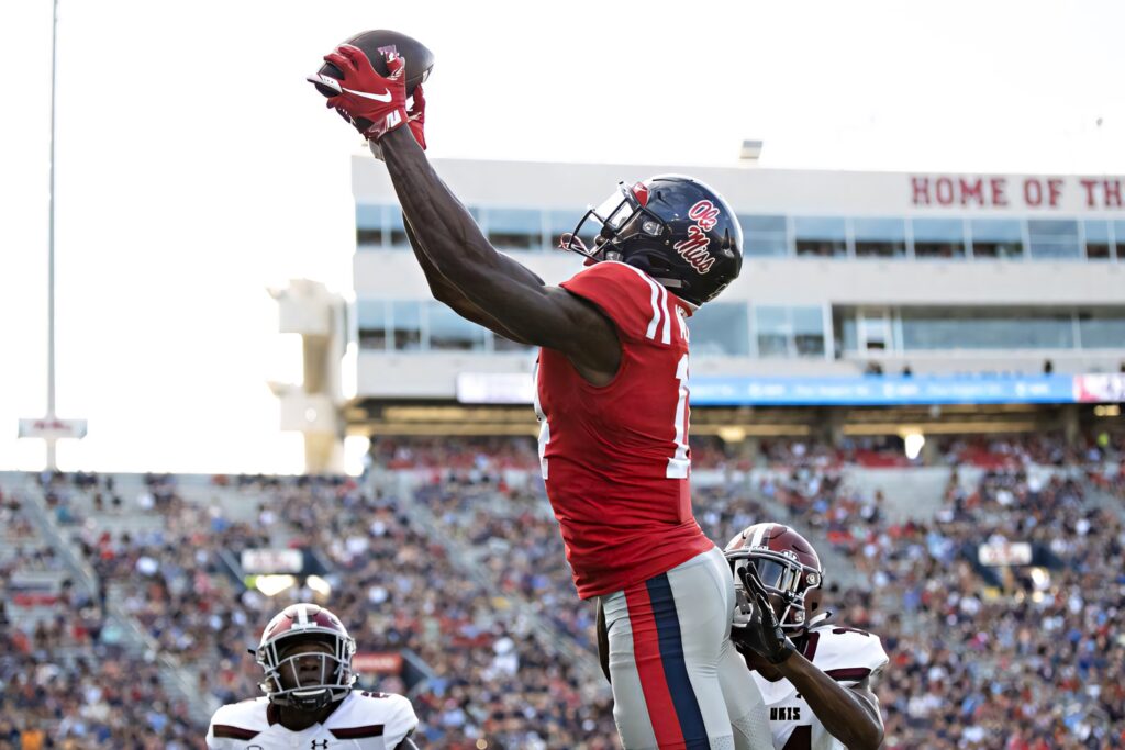 DK Metcalf leaps for a catch in vibrant Ole Miss uniform in dynamic college football action wallpaper