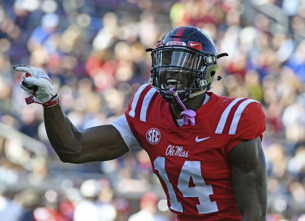 DK Metcalf in Ole Miss uniform number 14 confidently pointing during intense football game action Wallpaper