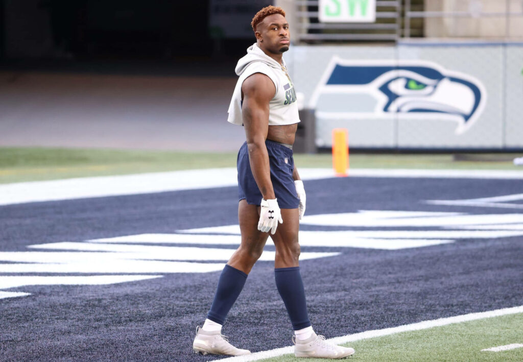 DK Metcalf in Seahawks stadium muscular physique vibrant team colors dynamic football wallpaper