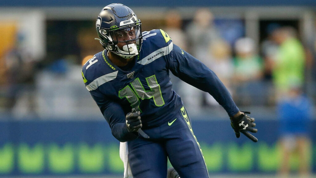 DK Metcalf Seattle Seahawks in action wearing blue neon green uniform on football field wallpaper