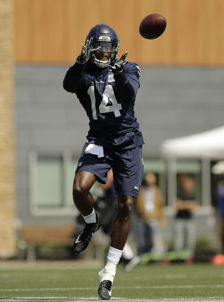 DK Metcalf Seattle Seahawks uniform catching football in practice dynamic athletic wallpaper