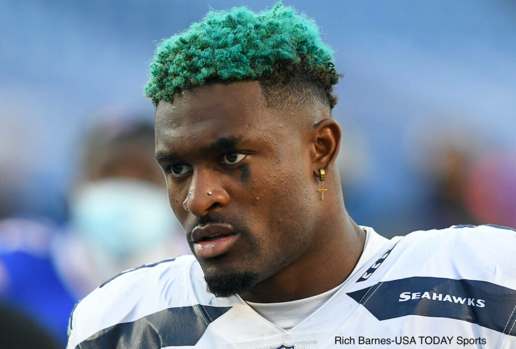 Dk Metcalf in Seattle Seahawks uniform with vibrant green hair intense focused close-up shot Wallpaper