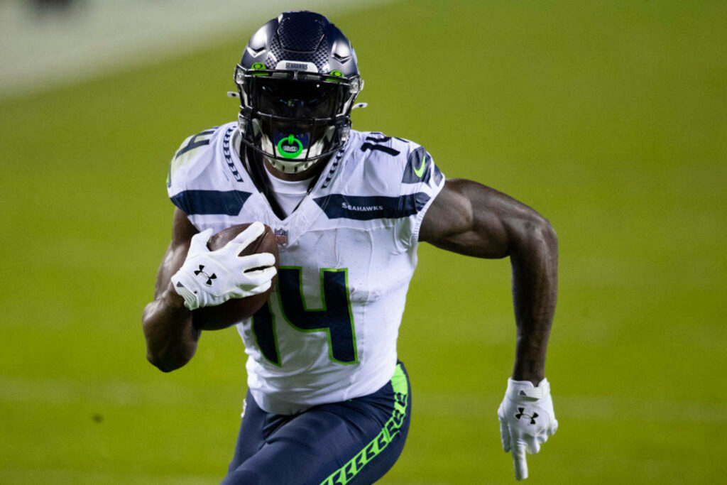 DK Metcalf Seattle Seahawks wide receiver sprinting in vibrant team colors dynamic football wallpaper