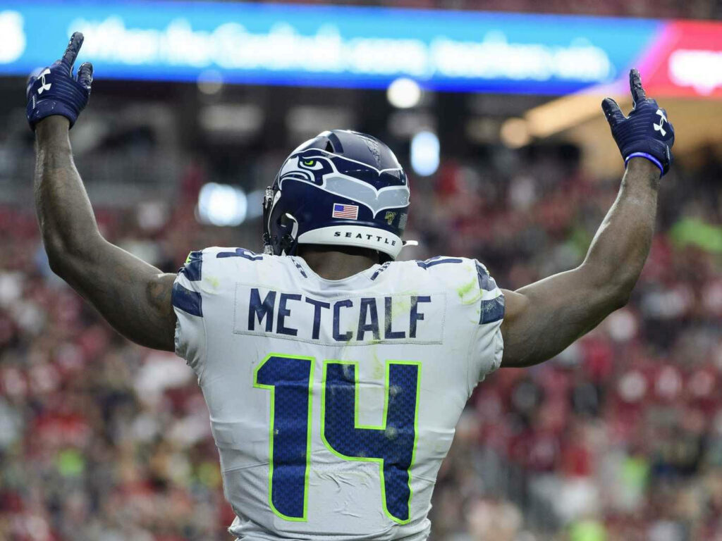 DK Metcalf Seattle Seahawks wallpaper raising arms triumphant stadium lighting fans athlete