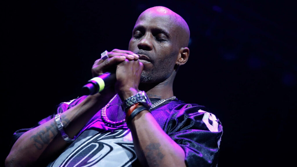 DMX sincere performance gripping microphone on stage dark background powerful emotion wallpaper
