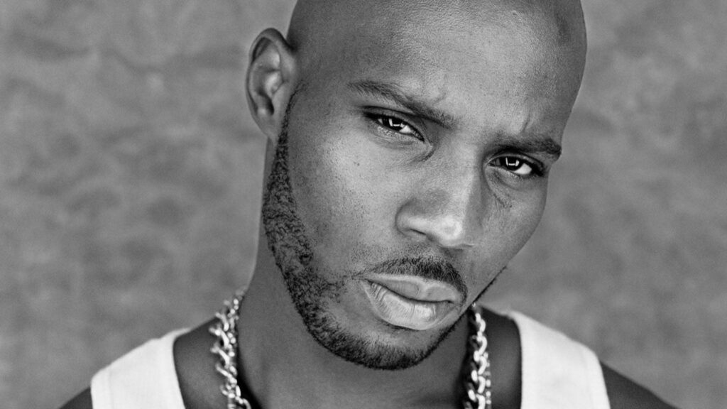 Grayscale close-up portrait of rapper DMX with intense expression bold chain and tank top wallpaper