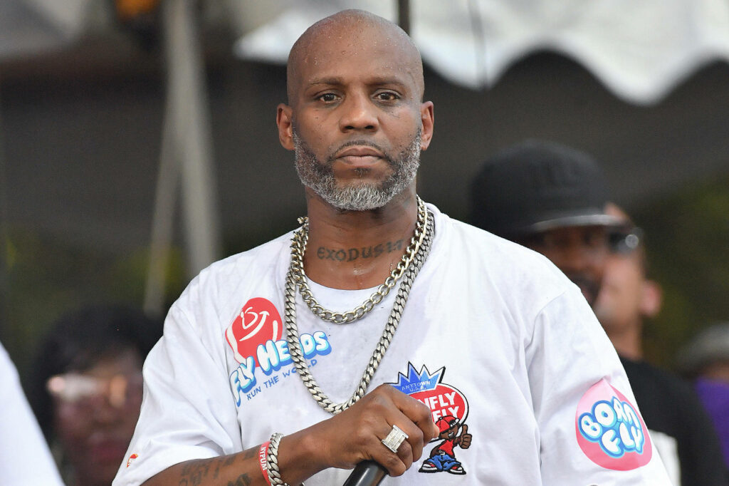 DMX holding microphone in white t-shirt and silver chains on outdoor concert stage wallpaper background