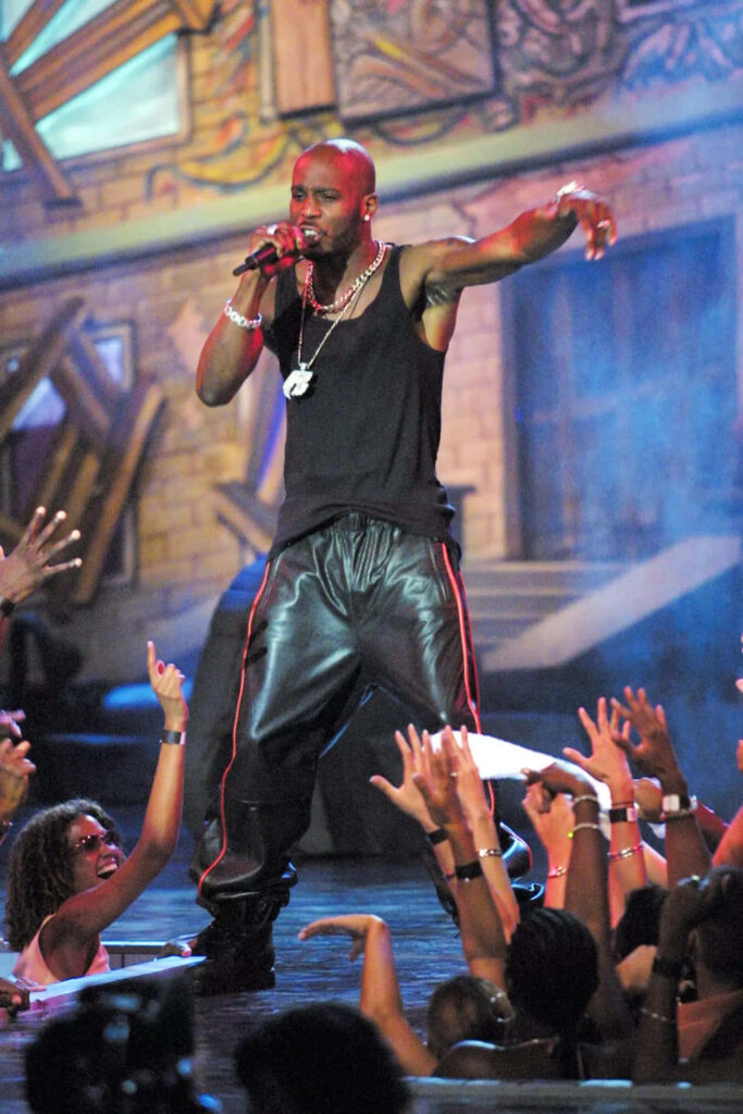 DMX performing on stage in black tank top leather pants with vibrant street art background Wallpaper
