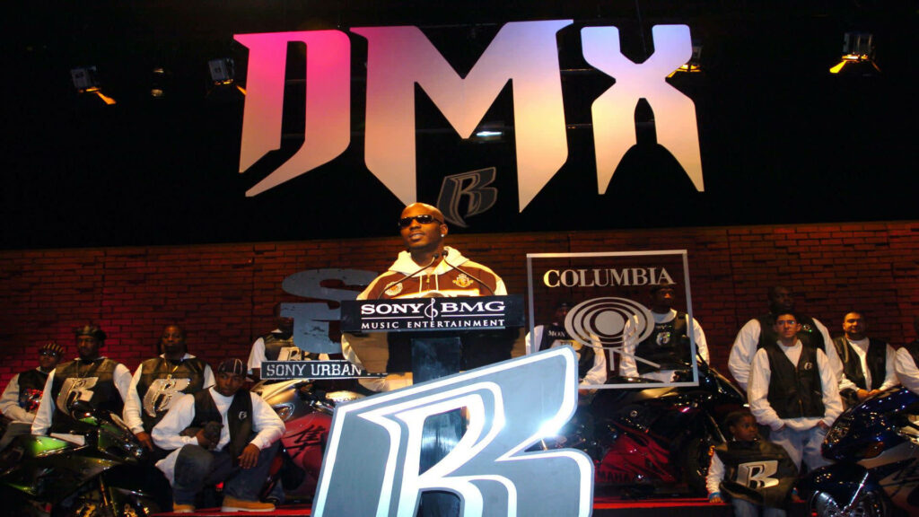 DMX memorial tribute wallpaper rapper at podium with Sony BMG Columbia logo vibrant lighting