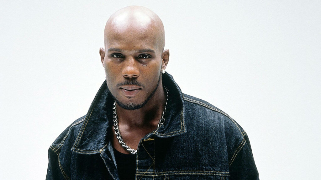 Young DMX confident pose dark denim jacket silver chain clean shaven minimal white background Wallpaper