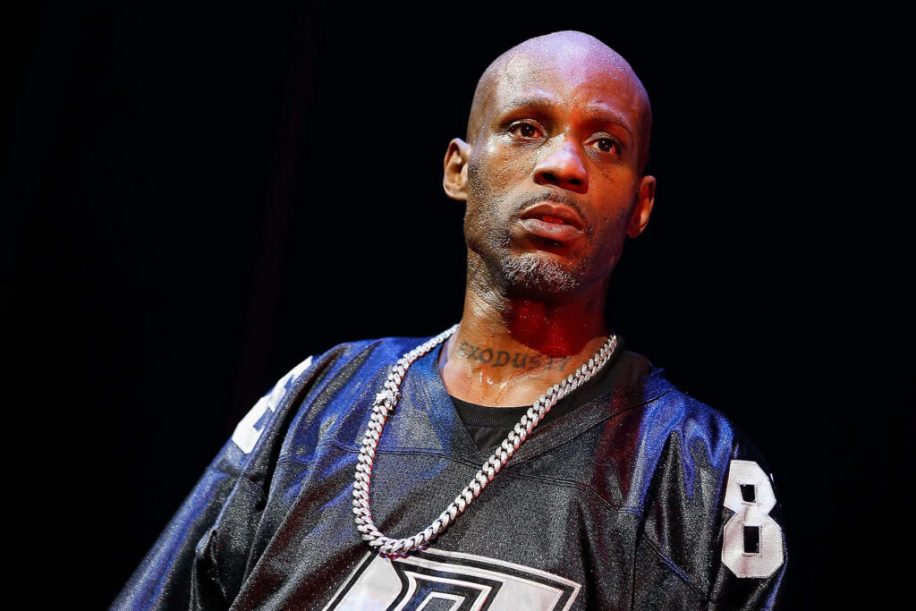 DMX on stage with intense expression iconic chain black sports jersey dramatic lighting wallpaper