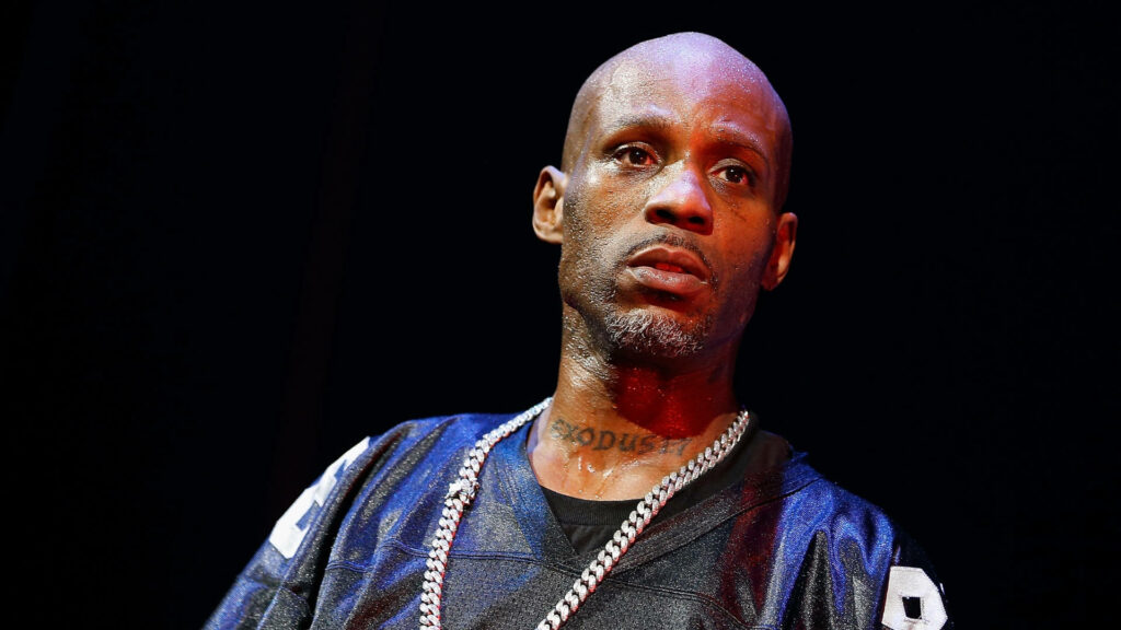 DMX performing live with intense expression wearing signature chain and dark jersey wallpaper background