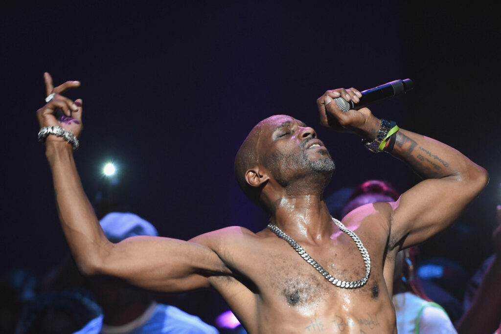 DMX shirtless performing live on stage with intense energy and vibrant crowd background wallpaper