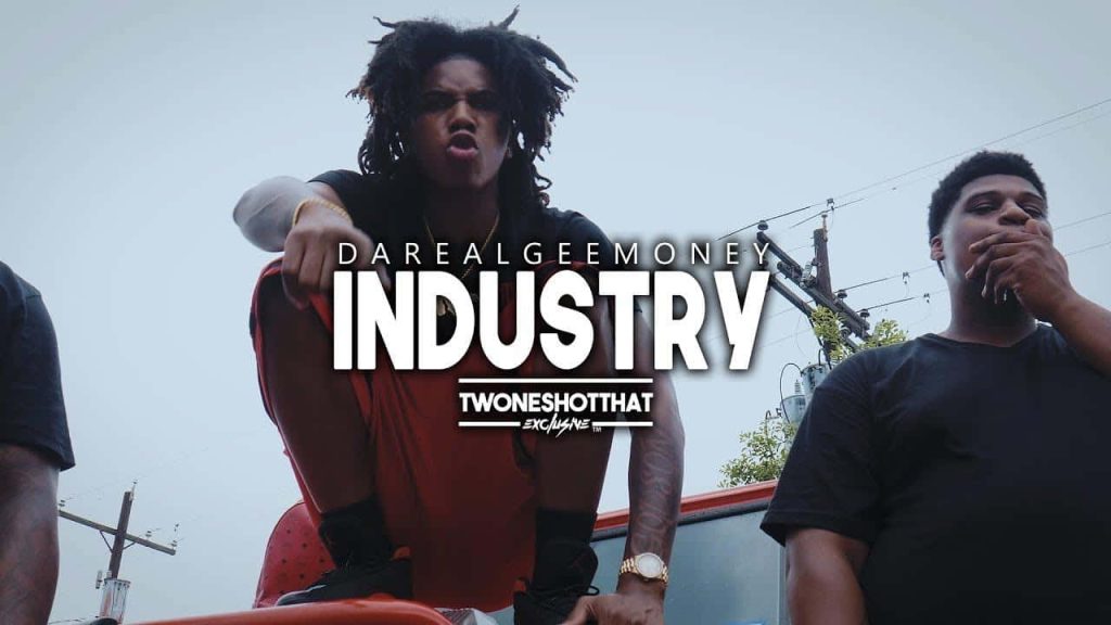 Da Real Gee Money wallpaper gritty outdoor shot with dreadlocks and bold Industry text background