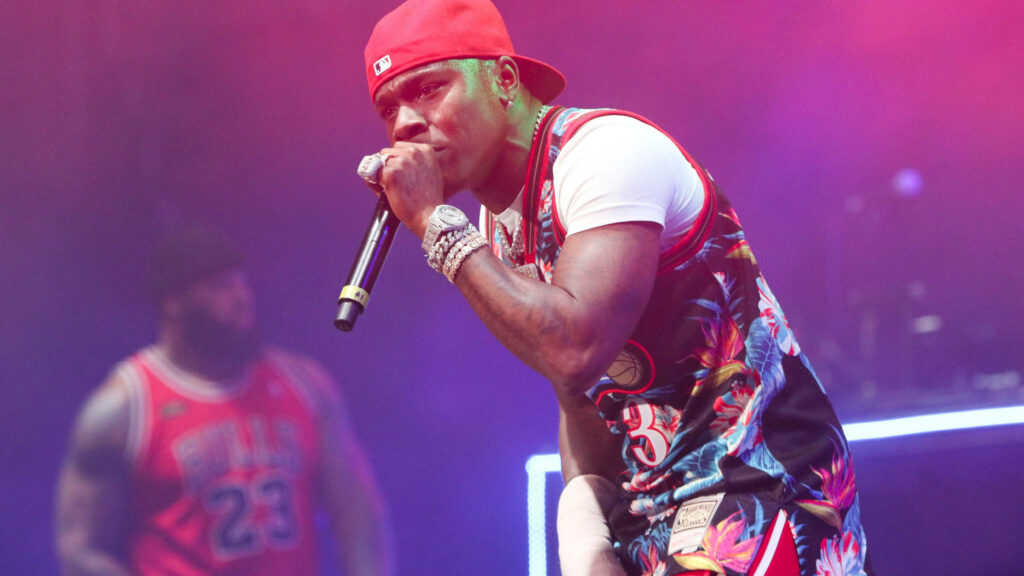 DaBaby live performance wallpaper vibrant pink purple lighting colorful sports jersey red cap